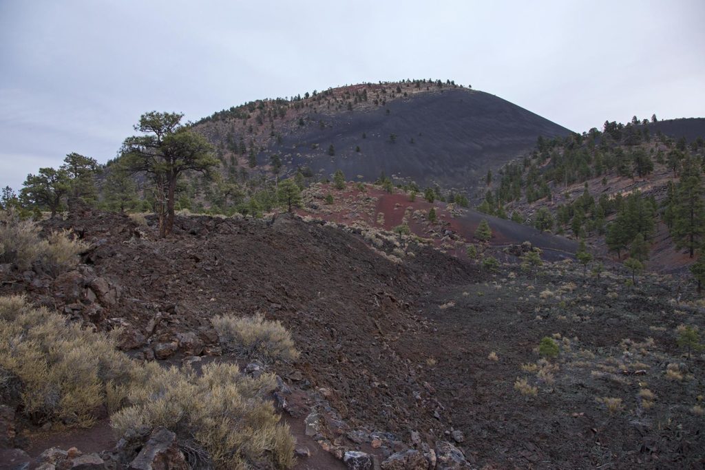 Sunset Crater Volcano is in the background. The foreground shows some of the lava rocks. 